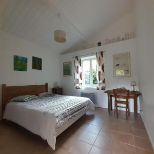 a bedroom with a bed and a table and a window at la petite maison in Espiet
