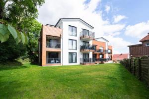 an apartment building with a green yard at Steife Brise Nr 2 in Neustadt in Holstein