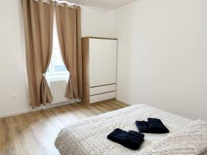 米卢斯RS-1 - Chaleureux 2 pièces au 1er étage tout équipé 1-3 pers的一间卧室，床上有两个枕头