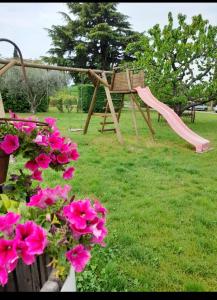 Rivoli VeroneseにあるAgriturismo Villa Stellaのピンクの滑り台とピンクの花のある遊び場