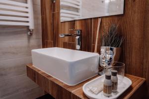 a white sink on a wooden counter in a bathroom at Hotel Słowik in Kielce +44 photos