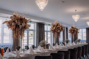 a long table with chairs in a room with chandeliers at Hotel Słowik in Kielce