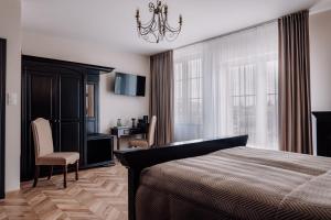a bedroom with a bed and a table and chairs at Hotel Słowik in Kielce