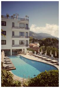 un hotel con piscina al lado de un edificio en Hôtel Le Versailles, en Villefranche-sur-Mer