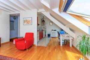 Una sala de estar con una silla roja y una mesa. en LE NID DES MOUETTES, en Cherbourg-en-Cotentin 4 fotos más