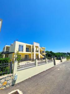 a yellow building with a fence in front of it at IVANA Apartments in Ulcinj
