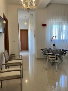 una sala da pranzo con tavolo, sedie e lampadario di Panorama sui trulli ad Alberobello