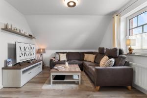 a living room with a couch and a coffee table at Schonergang Greetje Oog in Krummhörn