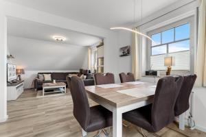 a dining room and living room with a table and chairs at Schonergang Greetje Oog in Krummhörn