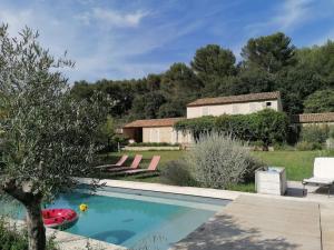 a pool in a yard with chairs and a house at Le Mazet d'Alexis in Maubec