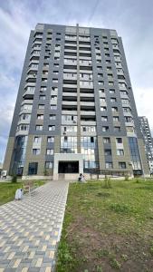 ein großes, hohes Gebäude mit einer Rasenfläche davor in der Unterkunft 1 комнатная драмтеатр 1bedroom apartment in Öskemen