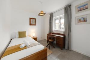 una camera da letto con un letto, una scrivania e una finestra di Casa do Alecrim a Óbidos Altre 10 foto