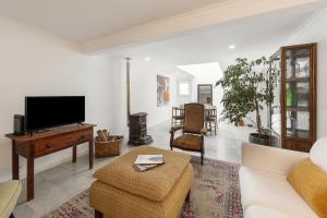 un soggiorno con un divano e una TV di Casa do Alecrim a Óbidos