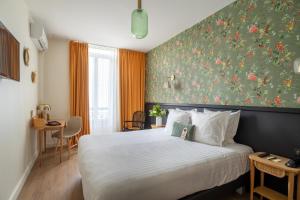 a bedroom with a bed with a floral wall at Hotel La Villa Nice Promenade in Nice