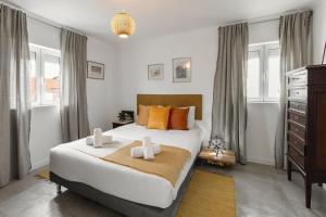 una camera con letto, cassettiera e finestre di Casa do Alecrim a Óbidos