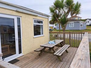 a wooden deck with a bench and a table at F40 Bayford, Riviere Towans in Hayle