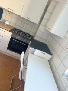 a white kitchen with a stove and a refrigerator at Al Capitello in Lacco Ameno +3 photos