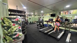 a woman walking on treadmills in a gym at Gran Lençóis Flat - Barreirinhas -MA in Barreirinhas
