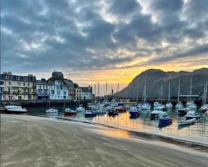 eine Gruppe von Booten, die bei Sonnenuntergang in einem Hafen anlanden in der Unterkunft ILFRACOMBE SEA ROCK 4 1 Bedroom in Ilfracombe