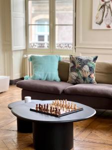 a table with a chessboard on it in a living room at L'Opéra, hyper centre de Rennes in Rennes