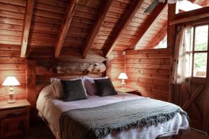 a bedroom with a bed in a log cabin at Cocos Cura Casas de montaña in San Carlos de Bariloche