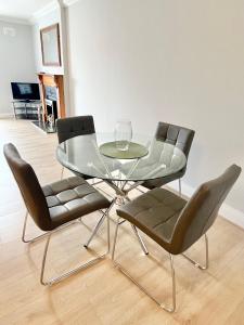 a glass dining table and chairs in a living room at Dublin City Apartment - 2 bedrooms in Dublin