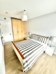 a white bedroom with a large bed and a lamp at Dublin City Apartment - 2 bedrooms in Dublin