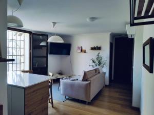 a kitchen and living room with a couch and a table at Apartamento Palacio de los Burgo in Pastrana