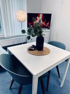a white table with chairs and a potted plant on it at Apartment FLIXI I Zentral & Gemütlich in Nordhorn