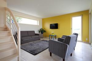 salon z żółtymi ścianami i kanapą w obiekcie Back2Front w mieście Boezinge