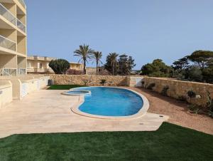 a swimming pool in a yard next to a building at Brand New Ta' Cenc Apartment in Sannat