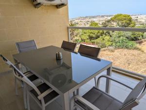 une table et des chaises sur un balcon avec vue dans l'établissement Brand New Ta' Cenc Apartment, à Sannat