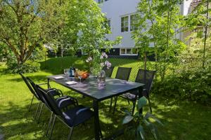a black table with chairs and flowers on it at HaHa Gothenburg City Apt for 2 in Gothenburg