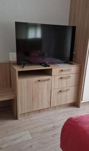 a large flat screen tv on a wooden entertainment center at Apartment Downtown,parking in Osijek