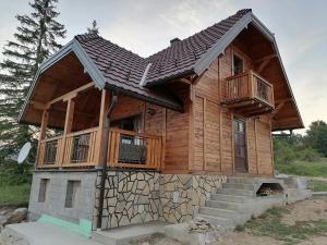 a log cabin with a balcony and stairs at Planinska kuca Mir in Sekulić 