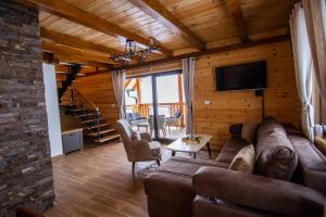 a living room with a couch and a tv at Planinska kuca Mir in Sekulić 