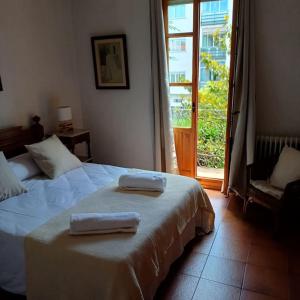 a bedroom with two towels on a bed with a window at Casa Julián in Las Navas del Marqués +41 photos