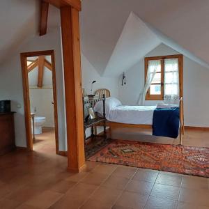 a bedroom with a bed and a bathroom with a window at Casa Julián in Las Navas del Marqués