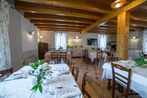 a dining room with white tables and chairs at Agriturismo Corte Morandini in Valeggio sul Mincio