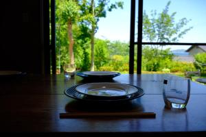 a wooden table with two plates and two glasses on it at 伊都山海渓 in Itoshima