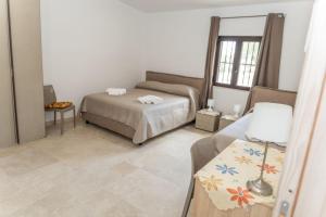 a bedroom with a bed and a table with a lamp at villa corinzia in Noto