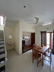 a living room with a table and a kitchen at Alchemist Villa-Kazhakootam in Trivandrum