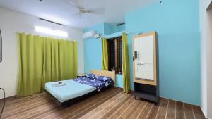 a small room with a bed and a mirror at Alchemist Villa-Kazhakootam in Trivandrum