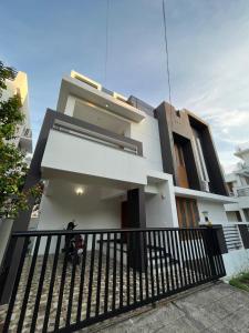 a house with a black fence in front of it at Alchemist Villa-Kazhakootam in Trivandrum