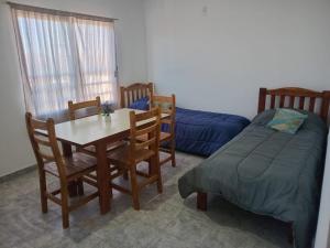 a bedroom with a table and a bed and a table and chairs at Departamentos Los dos Pinos in San José