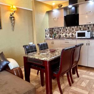 a kitchen with a table with chairs and a microwave at Apartment Orbi Sea Tower David in Batumi