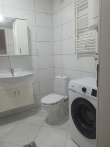 a white bathroom with a toilet and a washing machine at Design Prishtina Apartment 1 in Pristina +8 photos