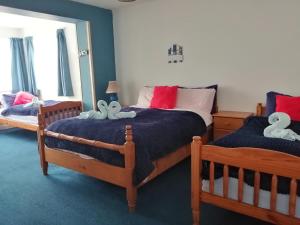 a bedroom with two beds with stuffed animals on them at Puffin rooms in Lisdoonvarna