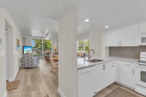 a kitchen with white cabinets and a dining room at Short Walk to Beach Access I Coastal 2 Bed Essex in Henry Key