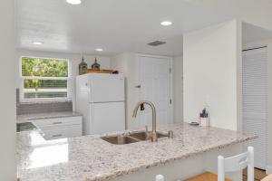 a kitchen with a sink and a white refrigerator at Short Walk to Beach Access I Coastal 2 Bed Essex in Henry Key